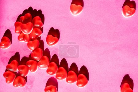 Téléchargez les photos : Contexte du 8 mars, jour de la Saint-Valentin. Bonbons assortis en forme de coeur rouge et blanc avec des messages d'amour imprimés sur fond rose. Cadeau pour la fête des mères des femmes, le 8 mars. Espace vide pour le texte. - en image libre de droit