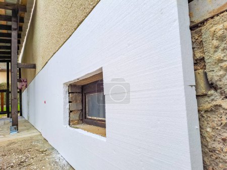 Builder installing rigid styrofoam insulation board for energy saving. Rigid extruded polystyrene insulation. High quality photo