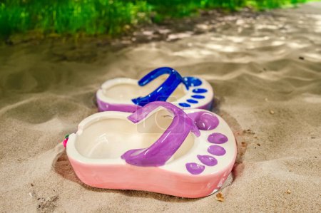 Photo for Ceramic ashtray in the shape of a flip flop by the sea. Tourism. Vacation Concept. High quality photo - Royalty Free Image