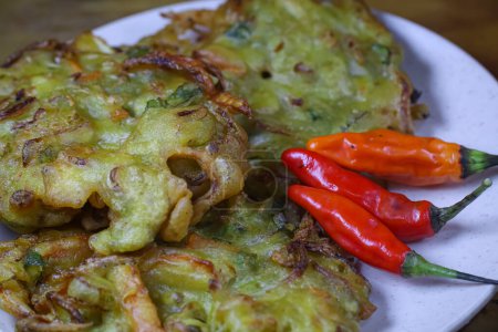 "bakwan "en un plato con chile, un aperitivo tradicional indonesio hecho con harina y verduras. 
