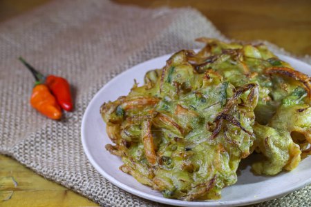 "bakwan "en un plato con chile, un aperitivo tradicional indonesio hecho con harina y verduras. 