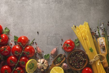 Foto de Fondo de comida italiana en la mesa de piedra. Macarrones, albahaca y verduras. - Imagen libre de derechos