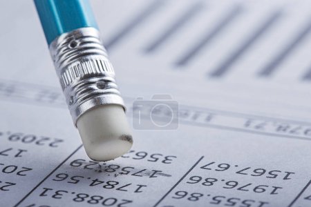 Buchhaltungsdokument mit Radiergummi löscht Flecken im Dokument und überprüft Finanzdiagramm. Konzept von Bankwesen, Finanzbericht und Finanzprüfung.