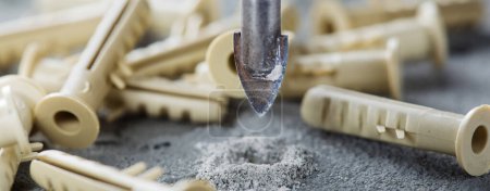 Metallbohrer machen Löcher in Betonwand auf industriellem Bohren