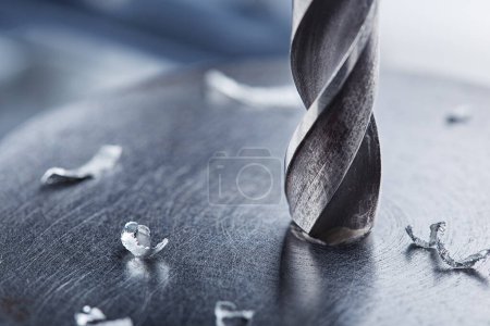 metal drill bit make holes in steel billet on industrial drilling machine