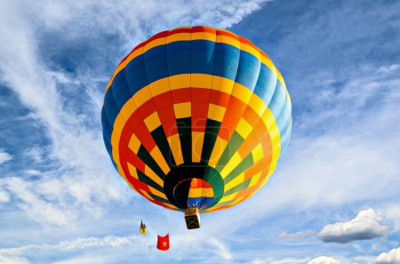 Photo for Colorful hot air balloon flying over blue sky with white clouds - Royalty Free Image