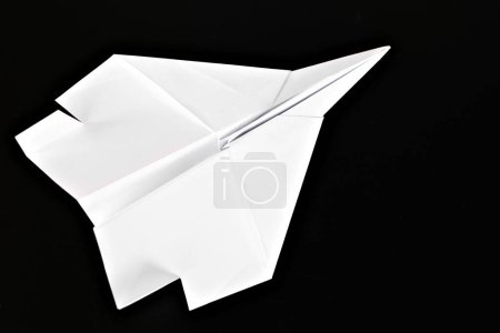 Photo for White paper plane isolated on black background. - Royalty Free Image