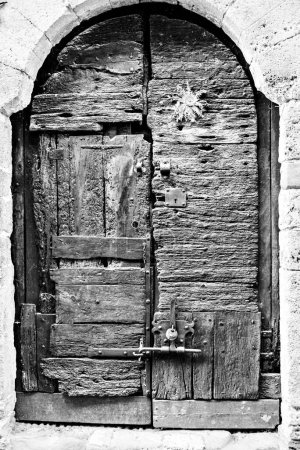 Foto de Antigua puerta de madera de una casa en la ciudad de Besal, Girona, España. Efecto blanco y negro - Imagen libre de derechos