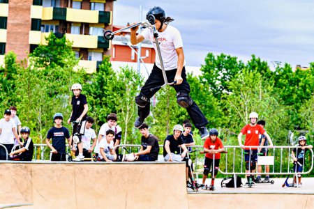 Téléchargez les photos : Igualada, Barcelone ; 16 juillet 2023 : Jeune homme pratiquant le Scootering (Freestyle Scootering) dans le nouveau Skate Park dans le parc central d'Igualada, Barcelone - en image libre de droit