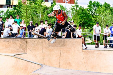 Téléchargez les photos : Igualada, Barcelone ; 16 juillet 2023 : Jeune homme pratiquant le Scootering (Freestyle Scootering) dans le nouveau Skate Park dans le parc central d'Igualada, Barcelone - en image libre de droit