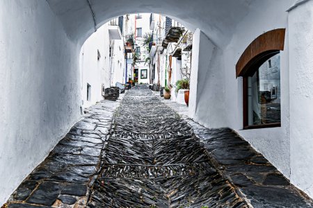 Typical cobbled street in the old town of the pretty town of Cadaques, Costa Brava, Girona, Spain