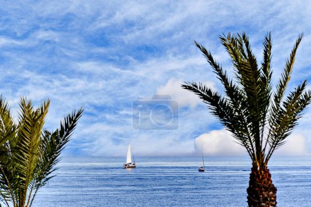 Spektakuläres Bild mit ruhigem Meer und Segelboot im Hintergrund am Strand von Aguadulce, Almeria, Spanien