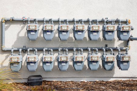 Rows of gas meters on the external wall of an apartment building