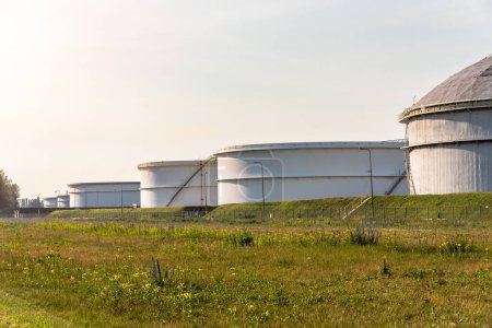 Téléchargez les photos : Grands réservoirs de pétrole brut dans un terminal pétrolier au coucher du soleil. Rotterdam, Pays-Bas. - en image libre de droit