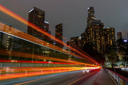 Téléchargez les photos : Los Angeles downtown skyline with light trails from the passing cars and buses at night in autumn. Los Angeles, CA, USA. - en image libre de droit
