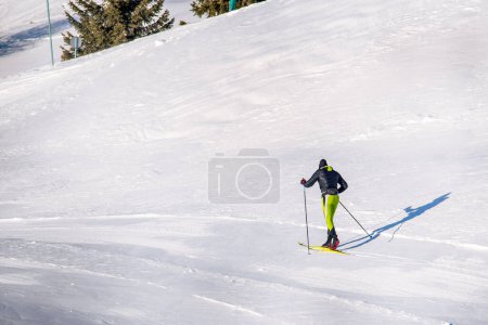 Foto de Man cross-country skiing on a ski track in the Alps on a sunny winter day - Imagen libre de derechos