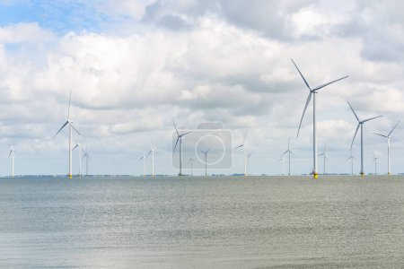 Foto de Filas de turbinas eólicas marinas para la generación de electricidad bajo el cielo nublado. IJsselmeer, Países Bajos. - Imagen libre de derechos