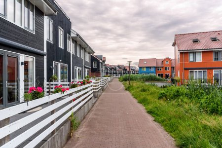 Téléchargez les photos : Terraced houses with rooftop solar panels along a deserted cobbled footpath on a cloudy day. Groningen, Netherlands. - en image libre de droit