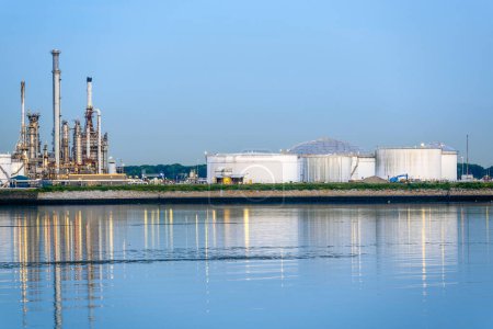 Foto de Oil tanks and distillation towers in a oil refinery in a commercial port at dusk. Rotterdam, Netherlands. - Imagen libre de derechos