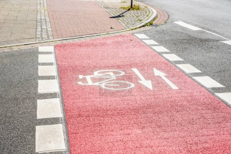 Foto de Cruce de bicicleta vacío marcado en rojo con forma de ciclo blanco y flechas en un centro de la ciudad. Bremen, Alemania. - Imagen libre de derechos