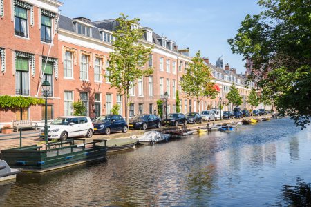 Foto de Fila de casas adosadas de ladrillo rojo a lo largo de un canal en un día claro de verano. La Haya, Países Bajos. - Imagen libre de derechos