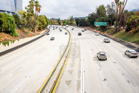 Photo for Modrate traffic on a freeway in Los Angels on a sunny autumn day. California, USA. - Royalty Free Image