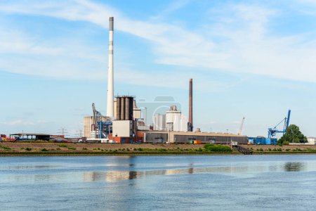 Photo for Riverside recycling and waste-to-energy plant under blue sky at sunset. Bremen, Germany. - Royalty Free Image