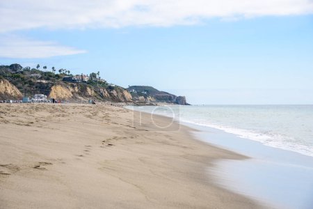 Photo for Sandy beach overlooked by clifftop houses on a partly cloudy autumn day. Zuma beach, Malibu, CA, USA. - Royalty Free Image