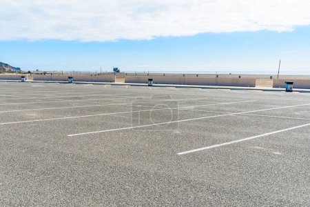 Photo for Deserted parking lot along a sandy beach on the coast of Californai on a sunny autumn morning. Malibu, CA, USA. - Royalty Free Image