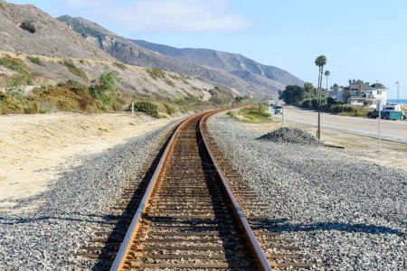 Téléchargez les photos : Voie ferrée vide longeant une route côtière en Californie par une journée ensoleillée d'automne - en image libre de droit