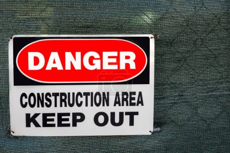 Téléchargez les photos : Gros plan du panneau d'avertissement sur une clôture à mailles de chaîne couverte entourant une zone de construction. Monterey, CA, États-Unis. - en image libre de droit
