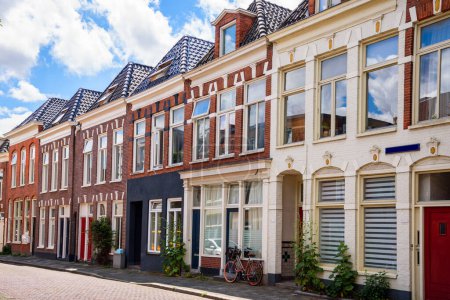 Foto de Casas antiguas a lo largo de una calle empedrada en un día soleado de verano. Groningen, Países Bajos. - Imagen libre de derechos