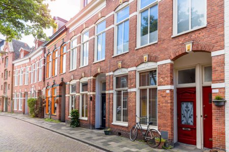 Alte Backsteinreihenhäuser in einer historischen Innenstadt lenken an einem sonnigen Sommertag ab. Groningen, Niederlande.