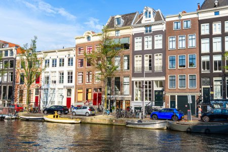 Photo for Traditional Duch townhouses along a canal in Amsterdam on a sunny summer day - Royalty Free Image