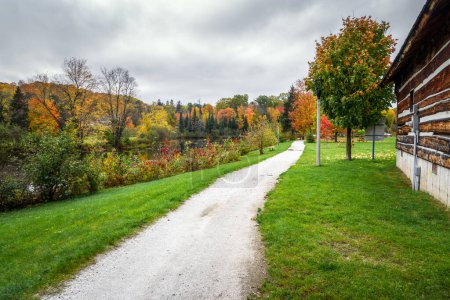 Téléchargez les photos : Chemin de gravier vierge le long de la rivière par une journée nuageuse d'automne. Superbes couleurs automnales sont le long de la rivière. Ontario, Canada. - en image libre de droit