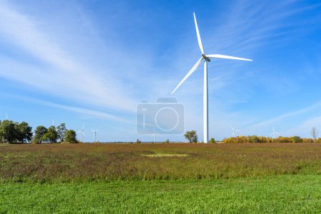 Foto de Turbina de viento alta en un campo en un día de Clea Ruautmn. Otras turbinas eólicas son visibles en la distancia. Wolfe Island, ON, Canadá. - Imagen libre de derechos