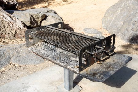 Téléchargez les photos : Barbecue public grill plein de cendres dans un parc par une journée ensoleillée d'automne. Parc national de Sequoia, Californie, États-Unis. - en image libre de droit