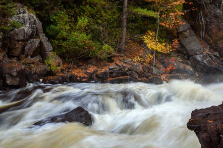 Foto de Agua que fluye rápidamente cerca de una cascada a lo largo de un río de montaña en otoño. Ragged Falls park, ON, Canadá. - Imagen libre de derechos