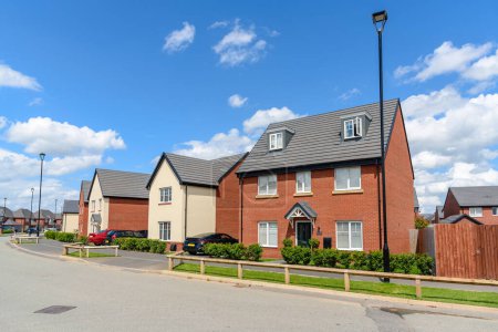 Photo for New brick detached houses along a street in housing development on a clear summer day. Chester, England, UK. - Royalty Free Image