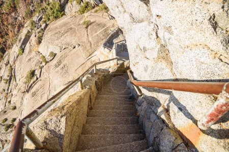 Téléchargez les photos : Escalier étroit et raide avec des mains courantes en métal le long d'un flanc rocheux d'une montagne au coucher du soleil en automne. Parc national de Sequoia, Californie, États-Unis. - en image libre de droit