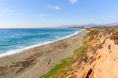 Téléchargez les photos : Plage de sable déserte au pied d'une falaise escarpée le long de la côte de Californie centrale par une journée d'automne ensoleillée - en image libre de droit