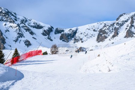 Téléchargez les photos : Skieurs sur une pente de montagne par une journée ensoleillée d'hiver - en image libre de droit