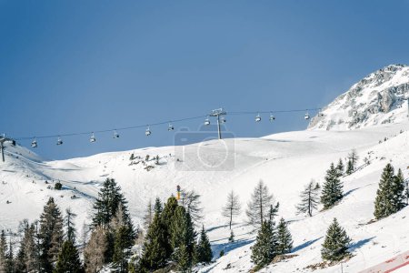 Téléchargez les photos : Charilift sur une piste de ski dans les Alpes par une journée d'hiver claire - en image libre de droit