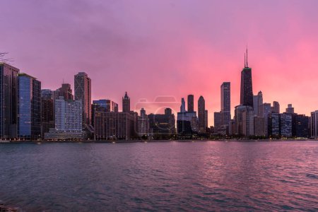Photo for Chicago skyline and waterfront under cloudy sky glowing in sunset light in spring - Royalty Free Image