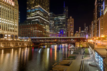 Foto de Vista cercana del centro de Chicago y el río. Sendero ligero dejado por un tren que pasa son visibles en el puente en primer plano. - Imagen libre de derechos