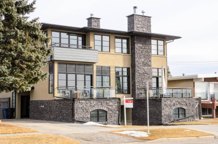 Téléchargez les photos : Panneau immobilier en face d'une maison jumelée en vente le jour nuageux d'hiver. Calgary, AB, Canada. - en image libre de droit