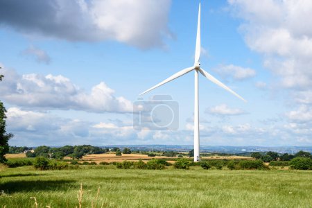 Foto de Turbina eólica en un paisaje rural ondulado en un soleado día de verano. Una ciudad es visible en el fondo. Sheffield, Inglaterra, Reino Unido. - Imagen libre de derechos