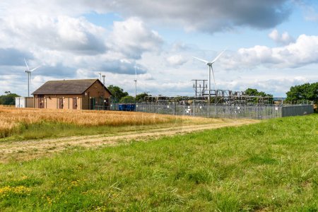 Foto de Subestación eléctrica con un parque eólico en el campo inglés en un soleado día de verano. South Yorkshire, Inglaterra, Reino Unido - Imagen libre de derechos