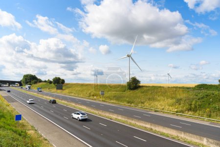 Téléchargez les photos : Parc éolien le long d'une autoroute dans la campagne anglaise par une journée ensoleillée d'été. South Yorkshire, Angleterre, Royaume-Uni. - en image libre de droit