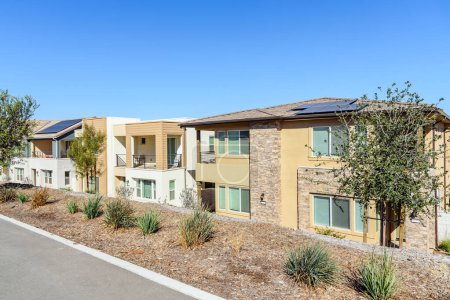 Foto de Fila de nuevas casas adosadas energéticamente eficientes con paneles solares en una urbanización de viviendas en un día claro de otoño. Santa Clarita, CA, Estados Unidos. - Imagen libre de derechos